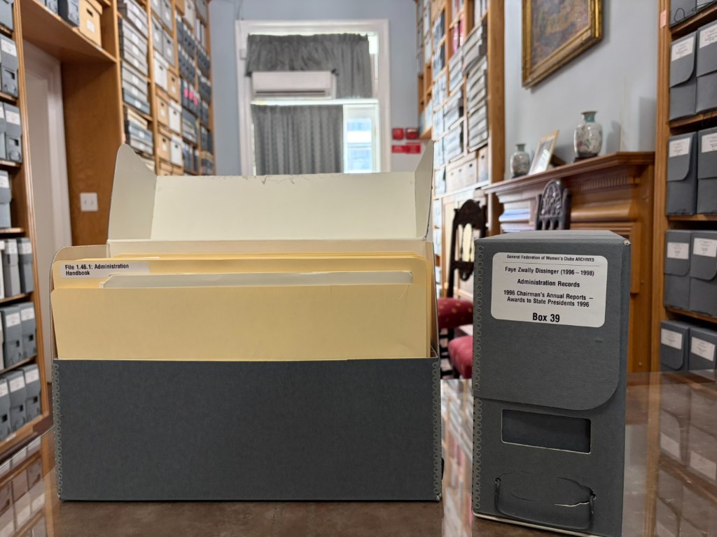 Processed and re-housed GFWC archival boxes with new labels on a table in the WHRC archives room.